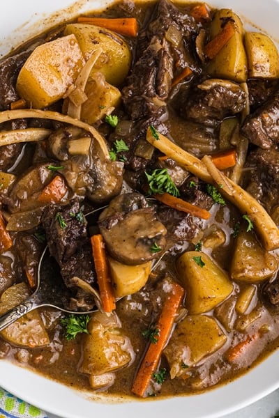 close up overhead shot of spoon in bowl of beef stew