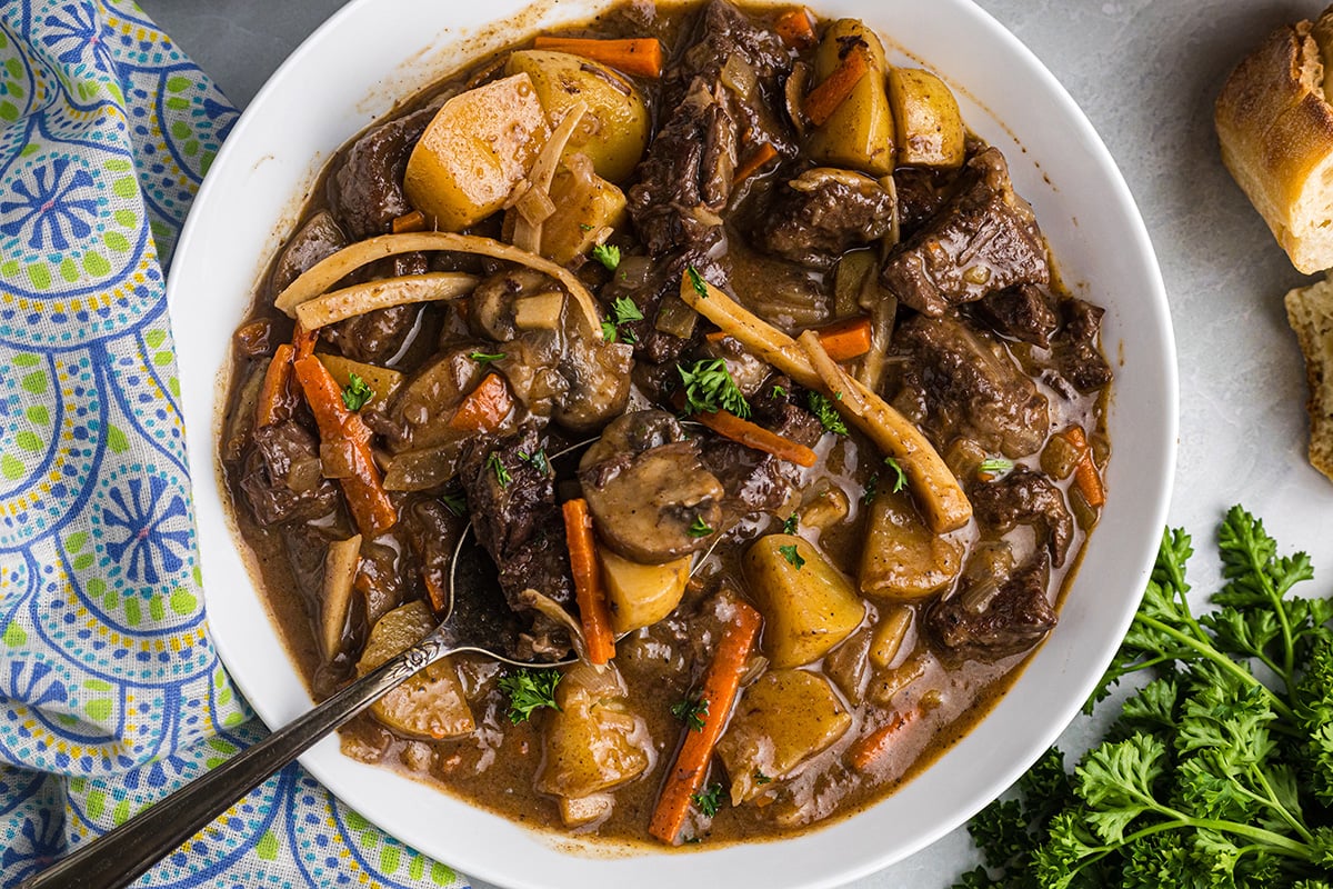 close up overhead shot of spoon in bowl of beef stew