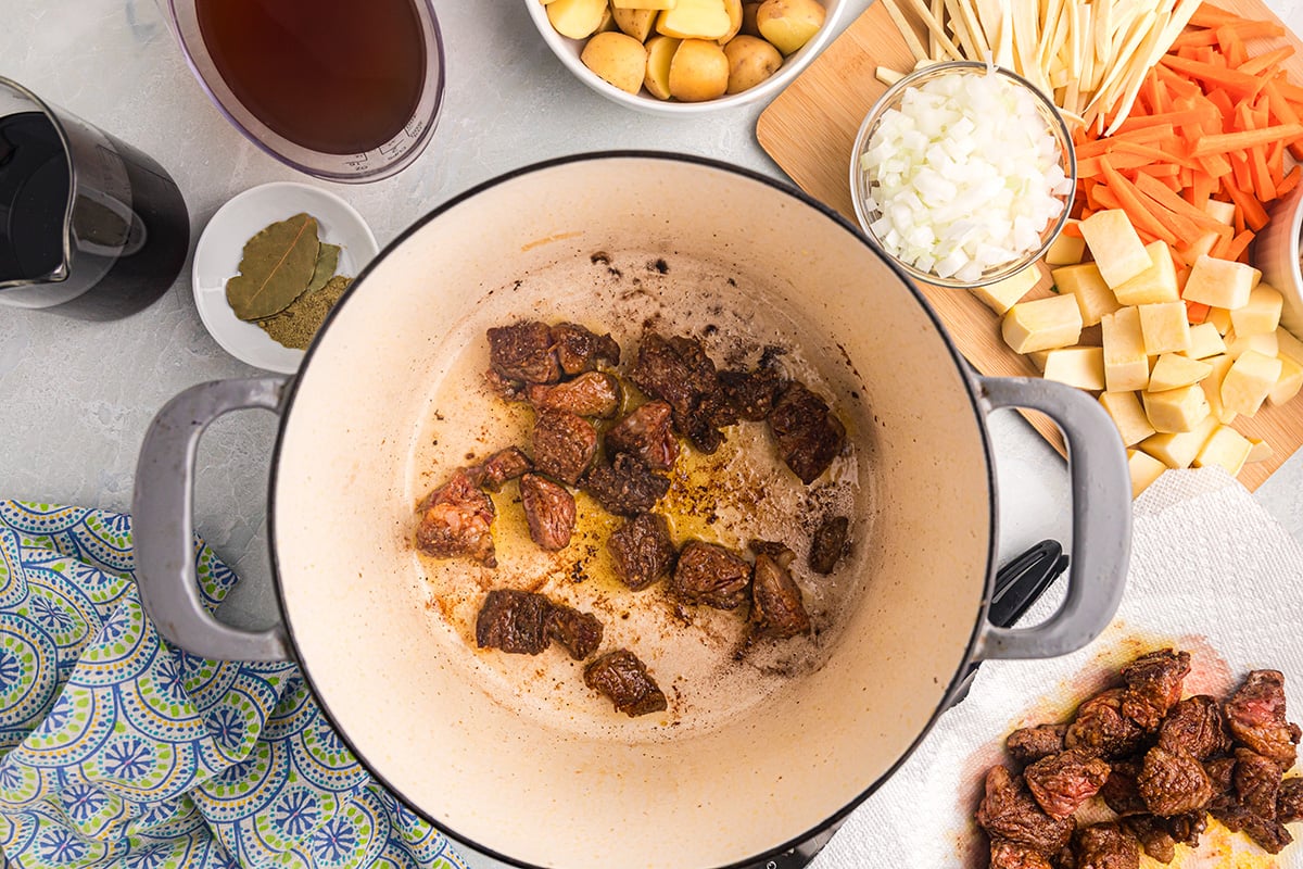 beef pieces cooking in dutch oven