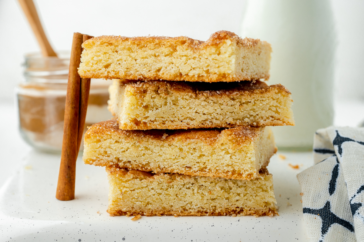 straight on shot of stack of snickerdoodle cookie bars with cinnamon stick