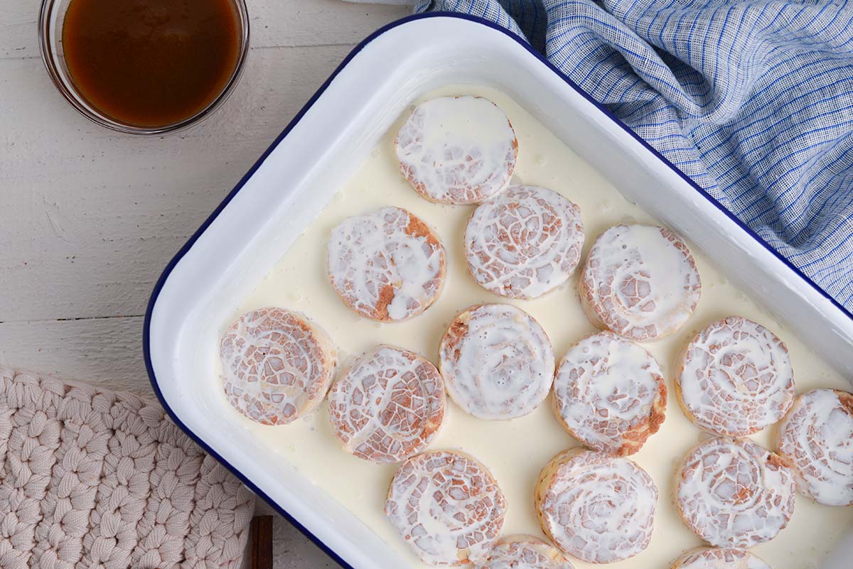 heavy cream poured over cinnamon rolls in baking dish