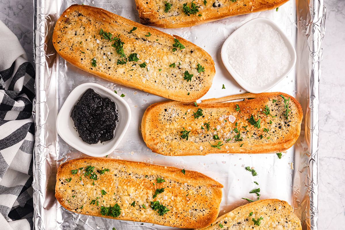 overhead shot of bowl of black truffle on pan with garlic bread