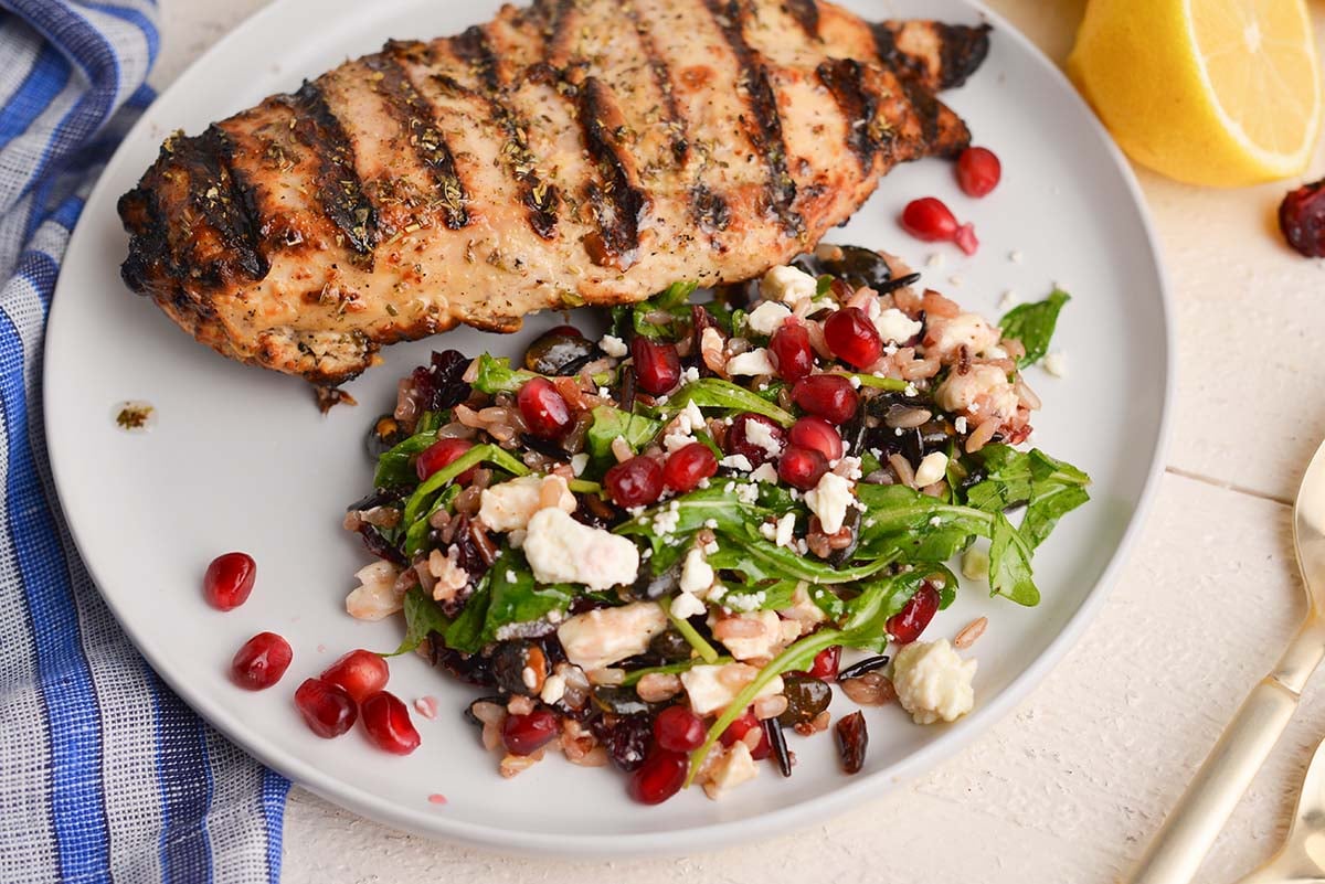 angled shot of plate of grilled chicken and salad