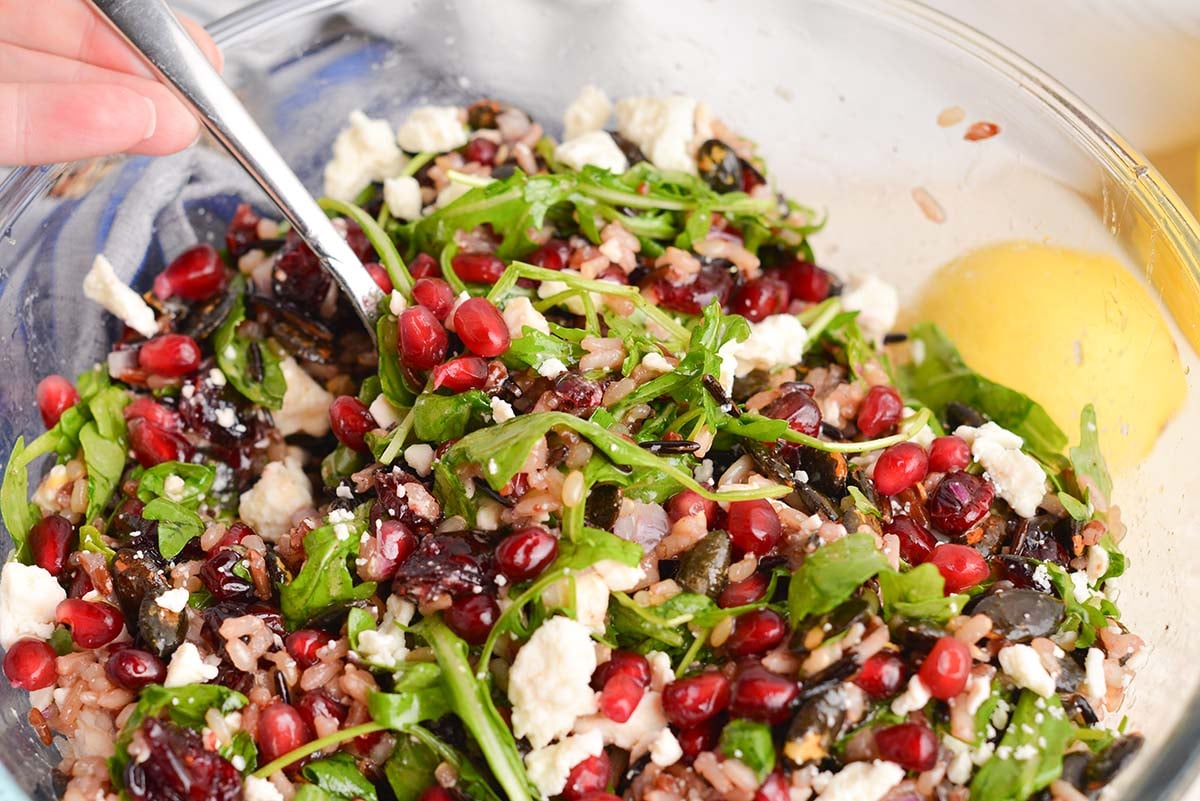 close up angled shot of fork in bowl of wild rice salad