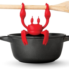 straight on shot of silicone crab on side of pot holding spoon