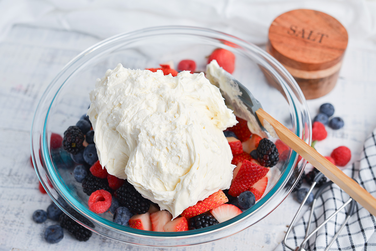 cream mixture added to bowl of berries