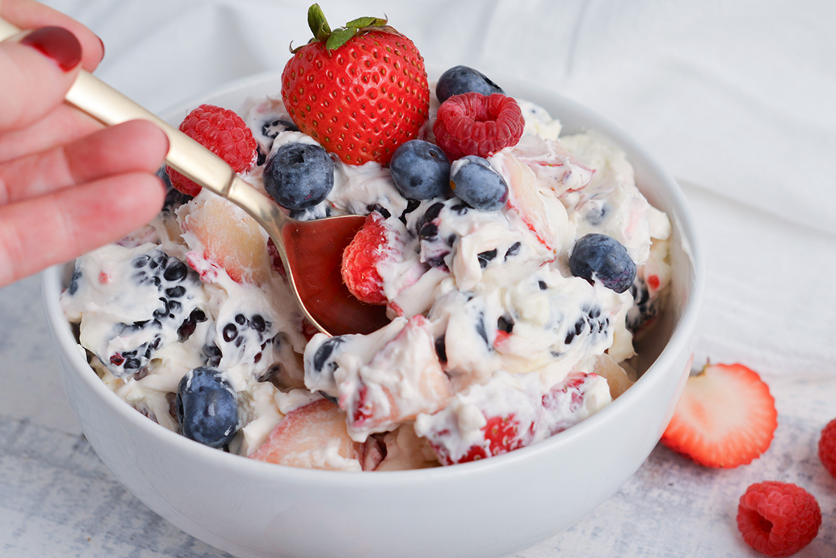 spoon in bowl of berry cheesecake salad