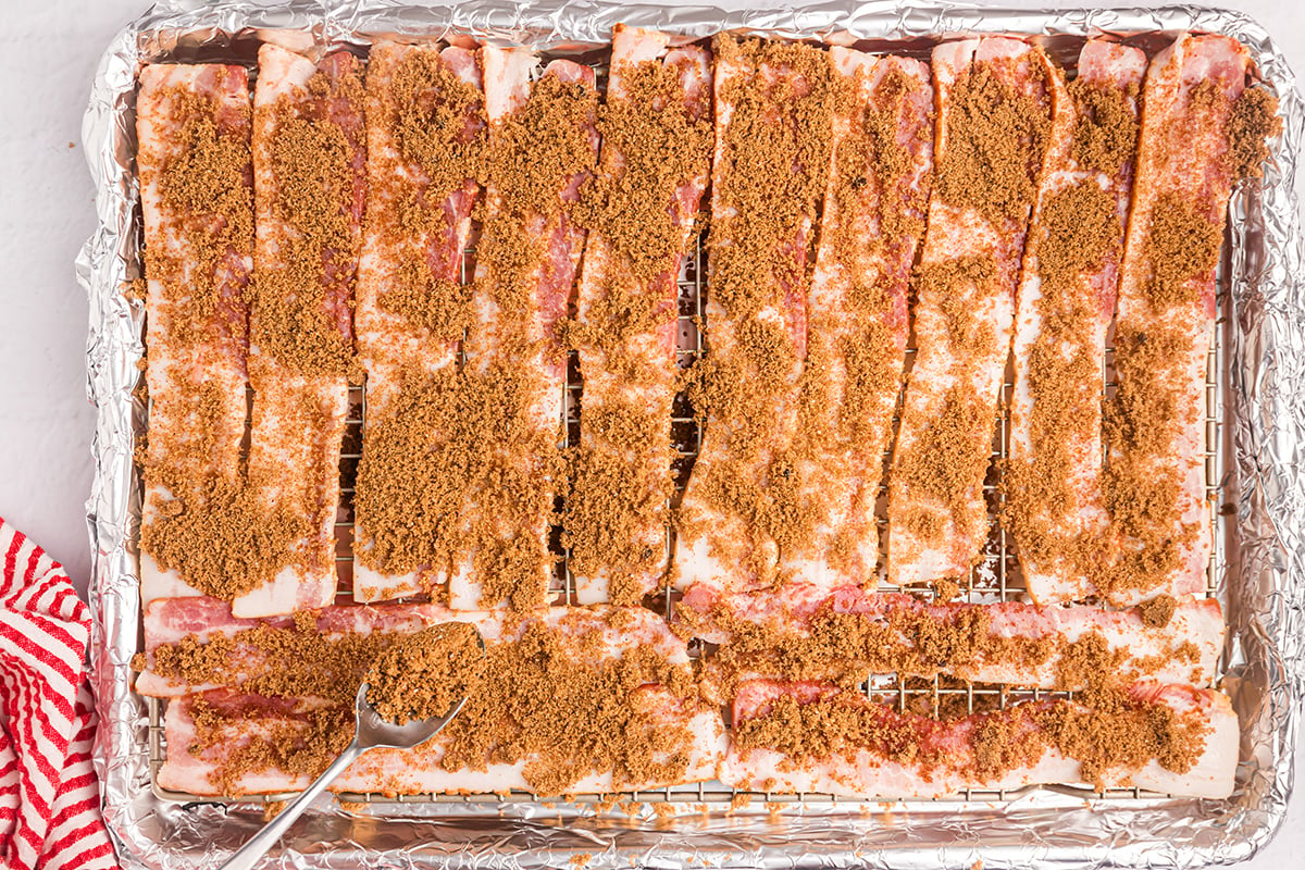 overhead shot of brown sugar mixture sprinkled over raw bacon