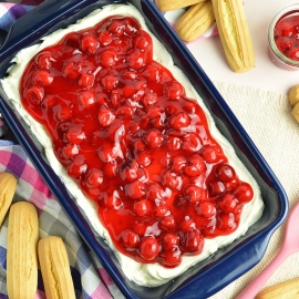 overhead of blue serving dish with cherry topping over dessert dip