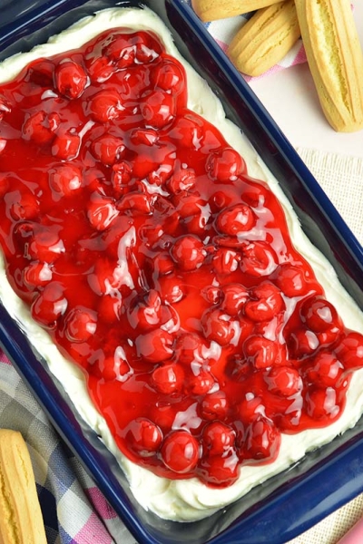 overhead of blue serving dish with cherry topping over dessert dip