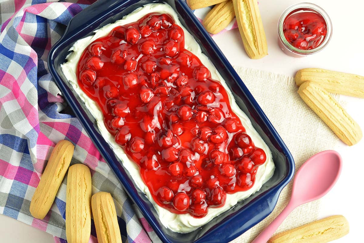 overhead of blue serving dish with cherry topping over dessert dip