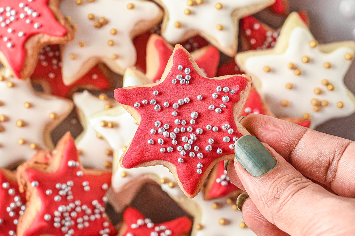 hand holding red frosted star cookies