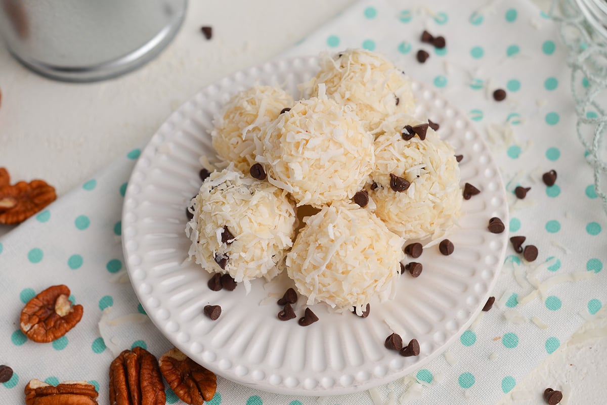coconut balls with pecans on a small white plate