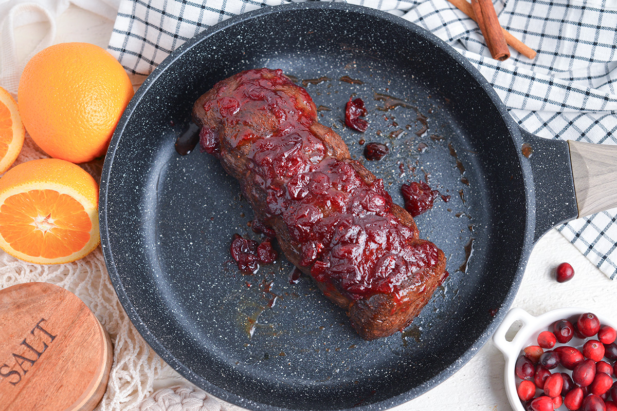overhead of roasted beef tenderloin with fresh cranberry sauce