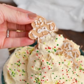 hand dipping cookie into eggnog dip