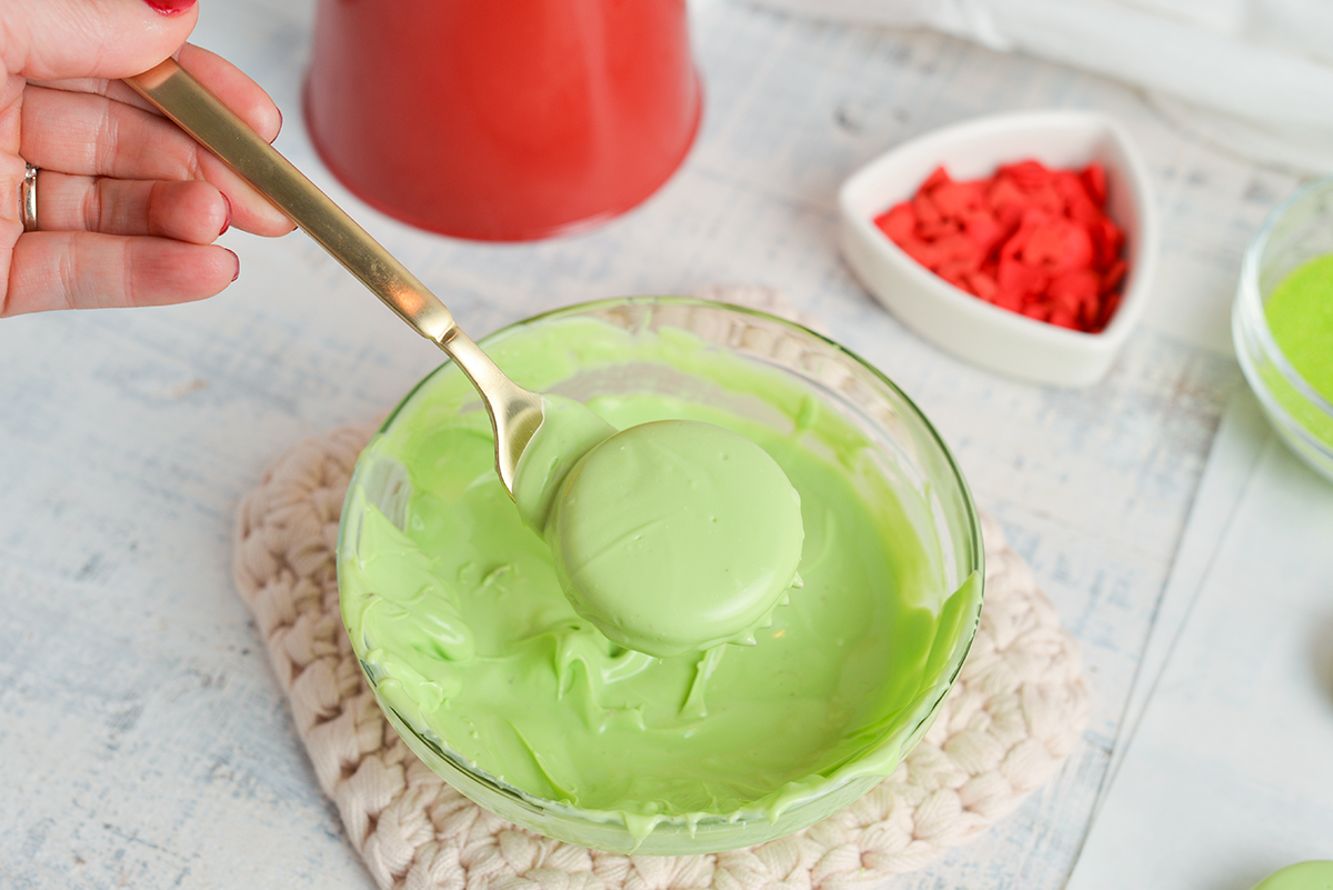 fork dipping oreo in green chocolate