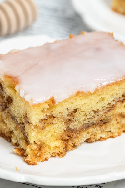 square slice of honey bun cake on a white serving plate