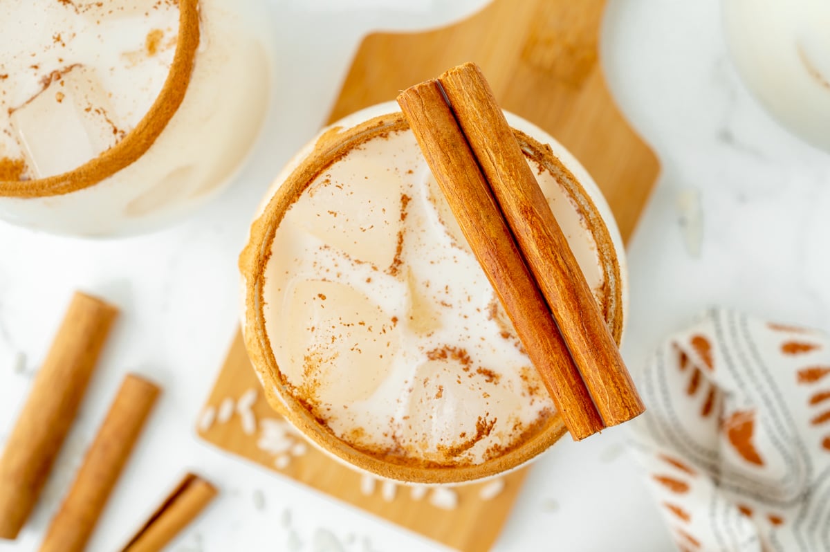 close up overhead shot of horchata in glass with cinnamon sticks