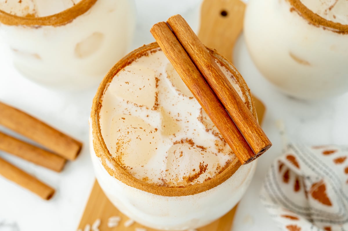 close up angled overhead shot of horchata in glass with cinnamon sticks
