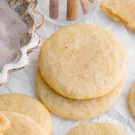 stack of two cinnamon sugar covered cookies on crumbled parchment