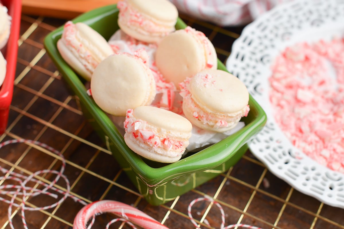 six candy cane macaron sandwiches in a green loaf pan