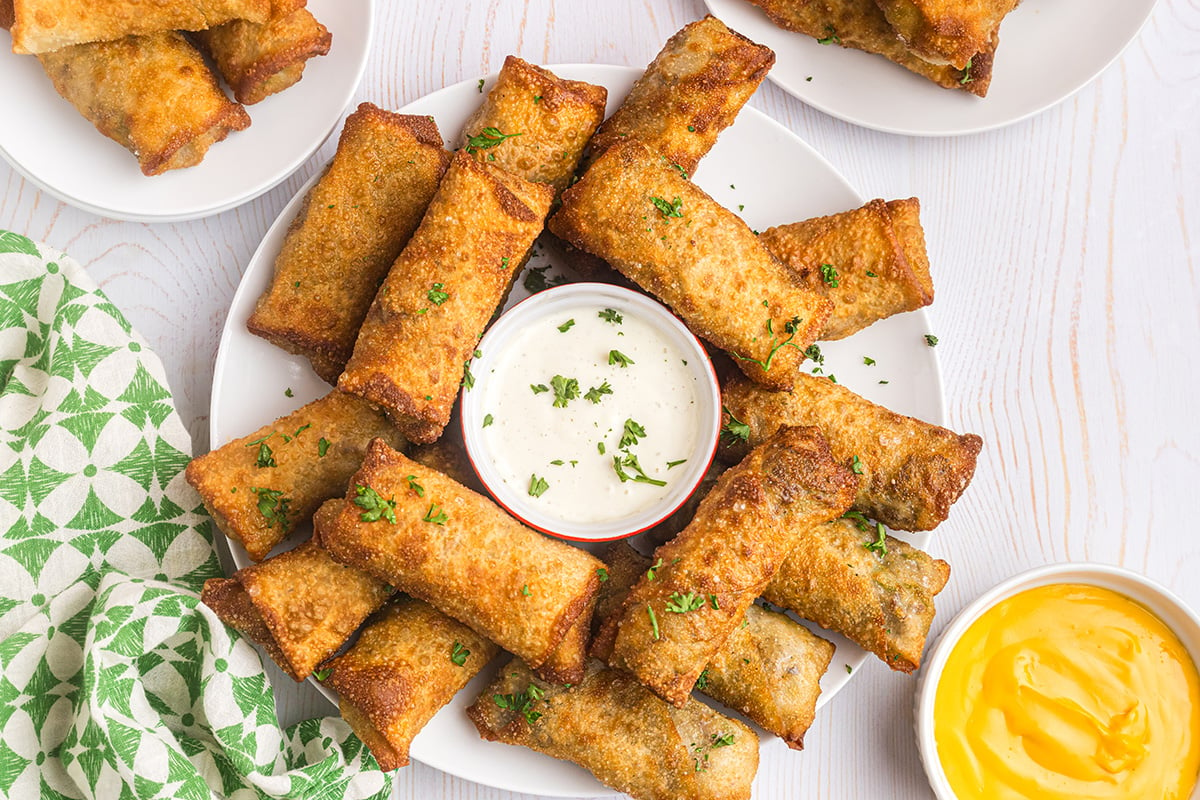 overhead shot of plate of egg rolls with dipping sauce