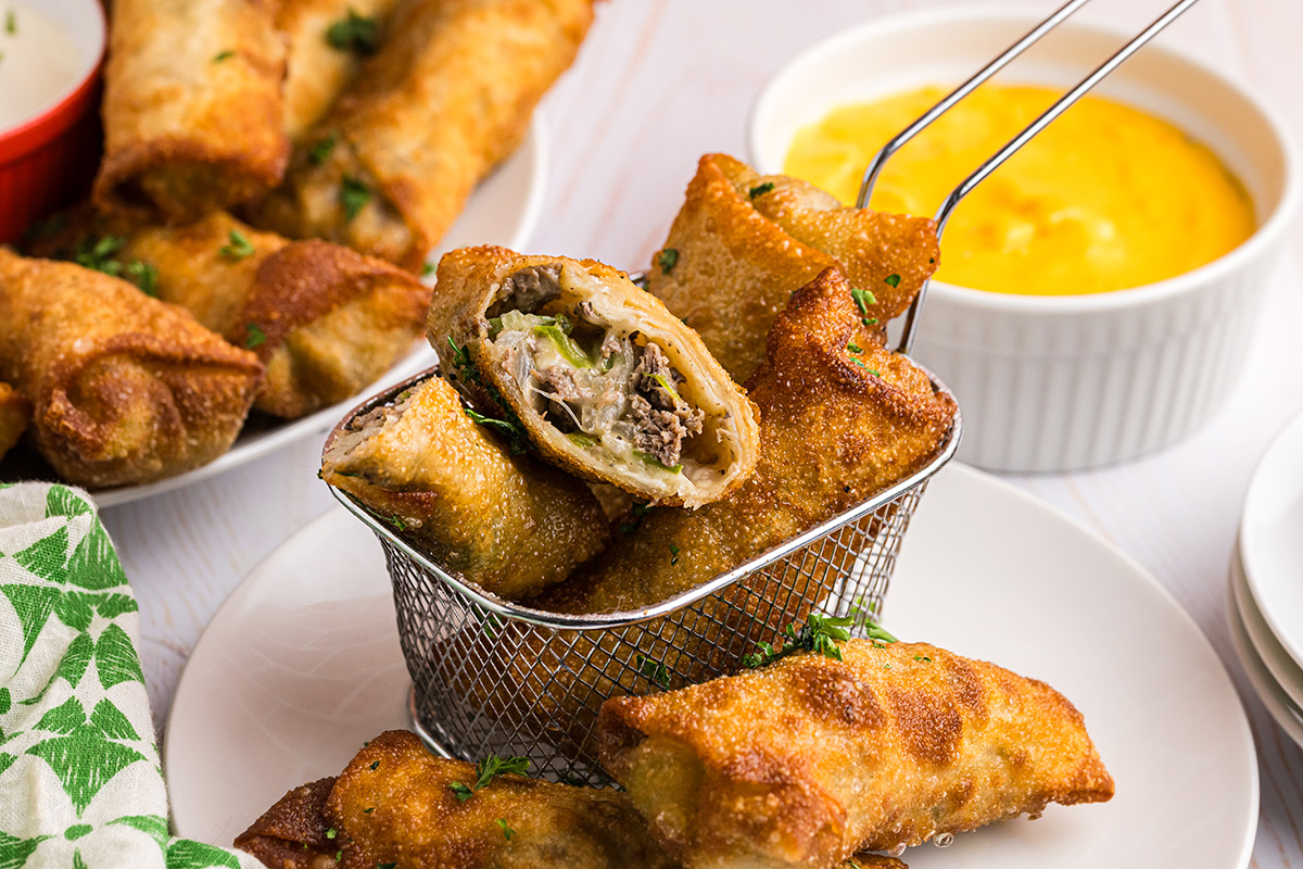 angled shot of basket of philly cheesesteak egg rolls