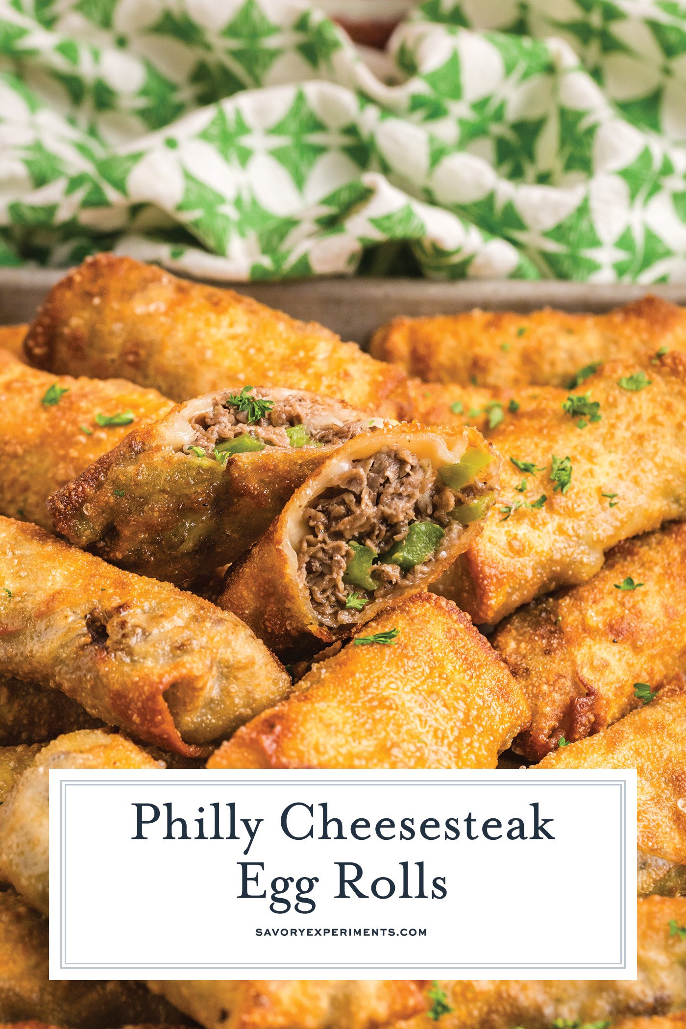angled shot of philly cheesesteak egg rolls with text overlay for pinterest