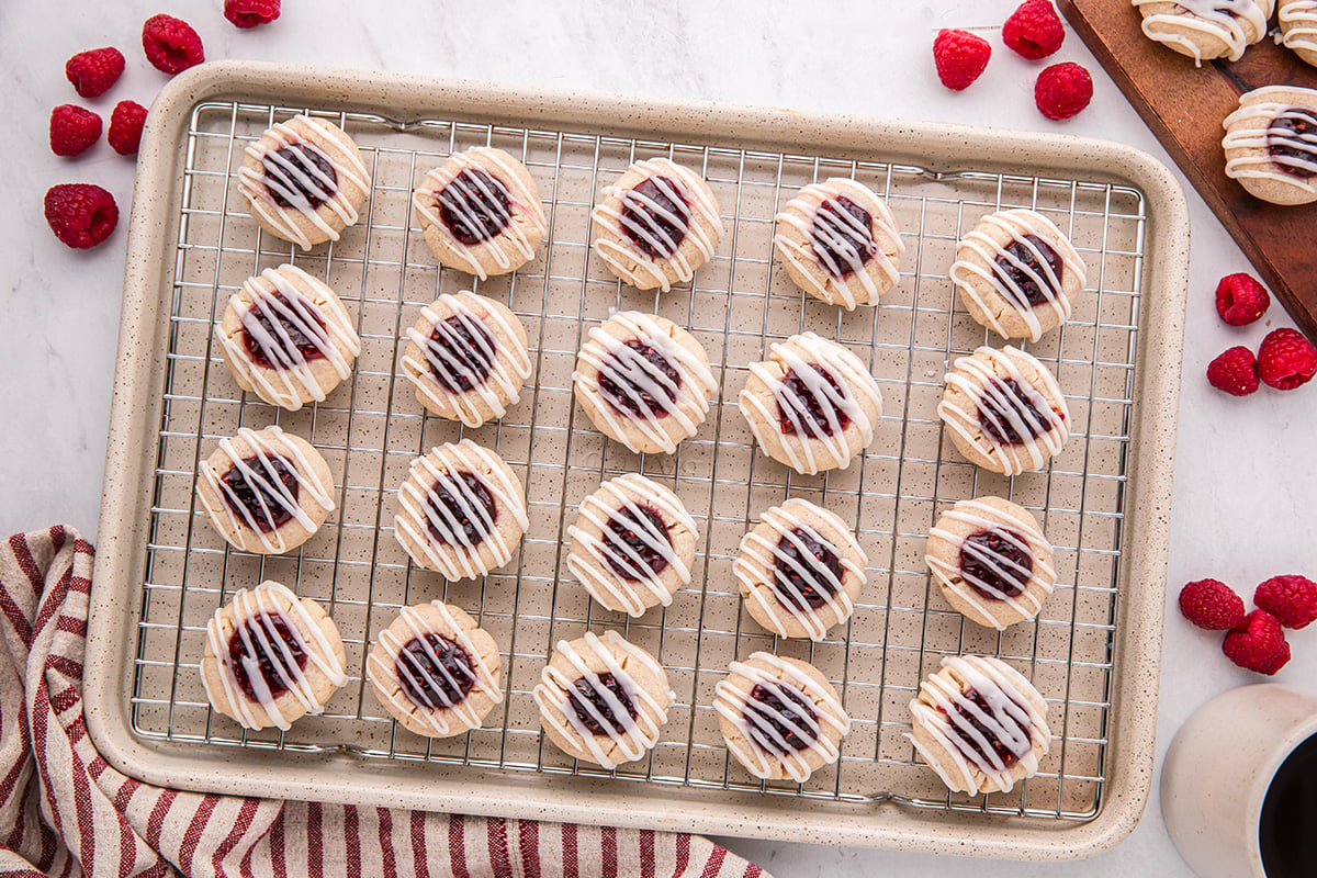 overhead shot of raspberry thumbprint cookies on cooling rack