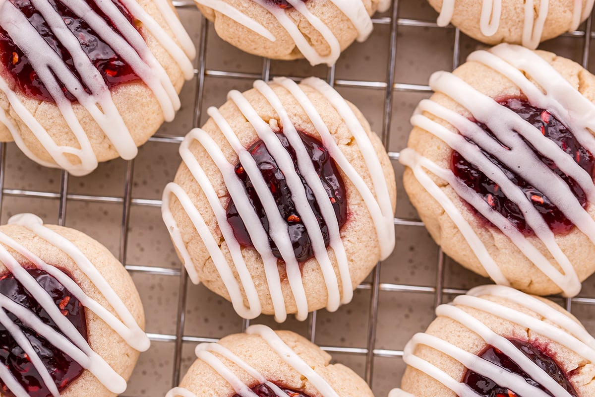 close up overhead shot of raspberry thumbprint cookies on cooling rack