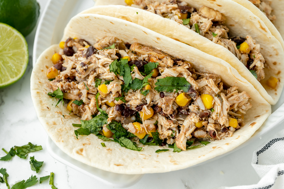 angled shot of slow cooker chicken tacos on plate