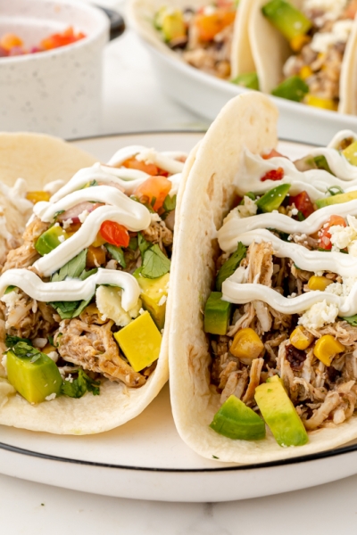 straight on shot of two chicken tacos on plate