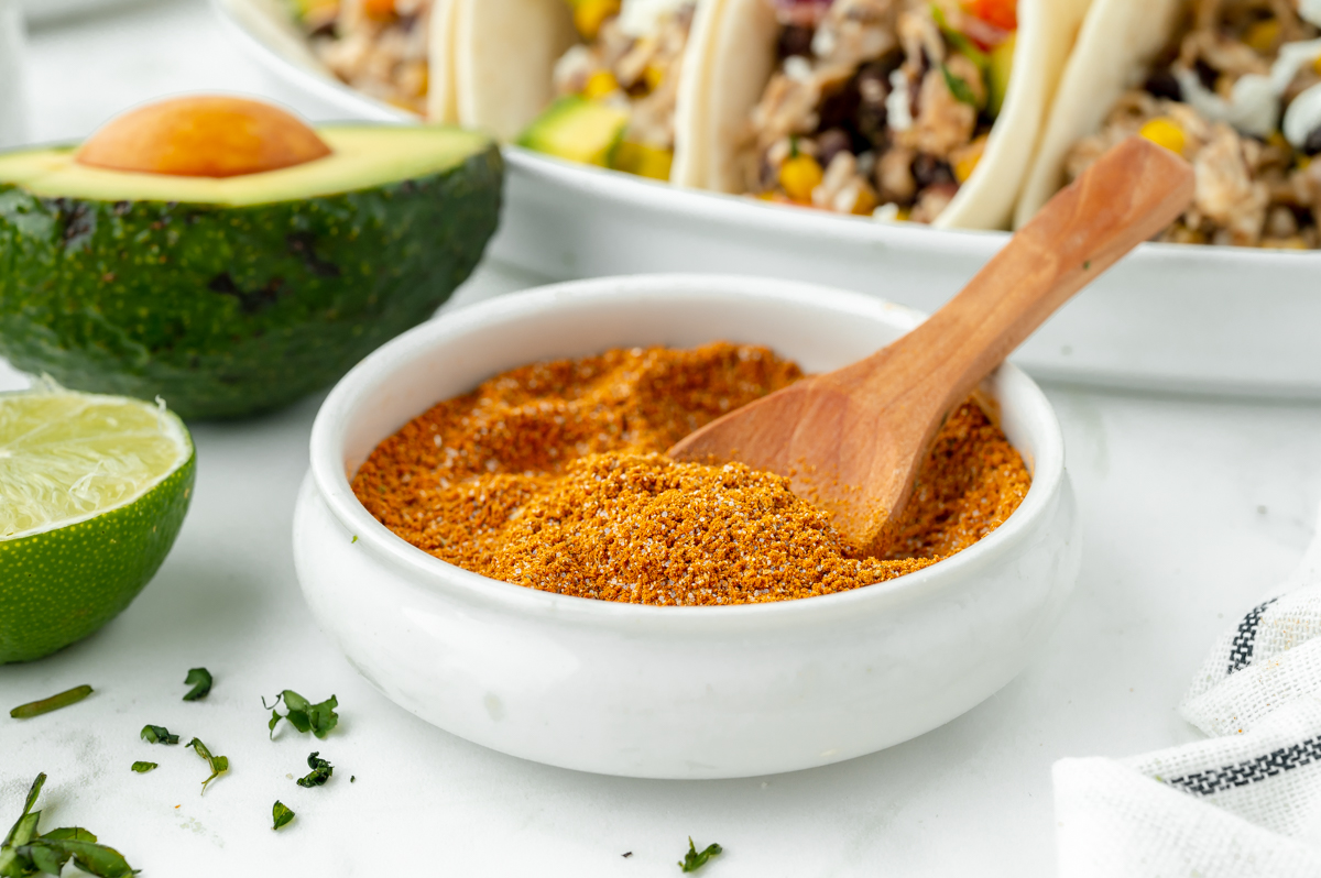 angled shot of wooden spoon in bowl of homemade taco seasoning