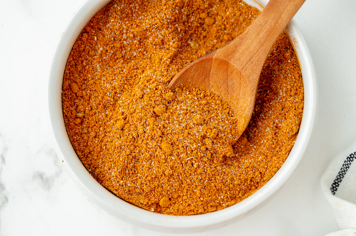 close up overhead shot of wooden spoon in bowl of homemade taco seasoning