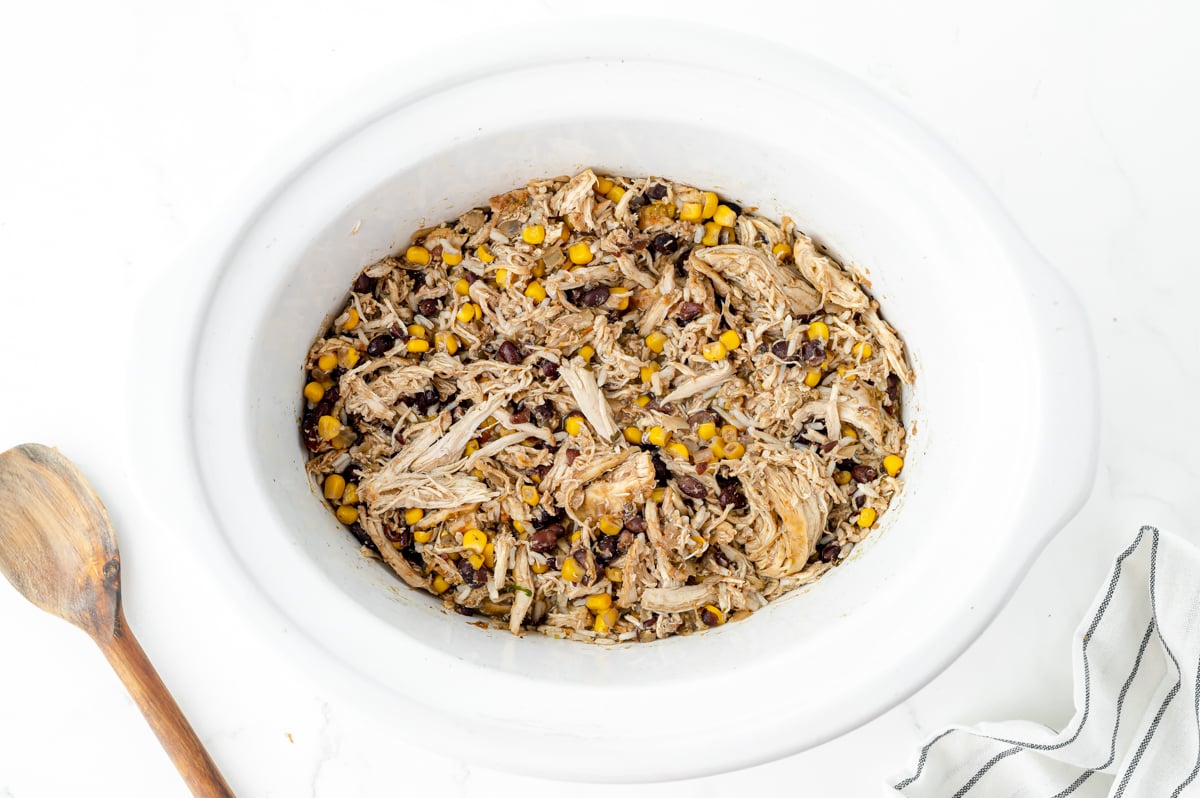 overhead shot of shredded chicken, corn and black beans in crock pot