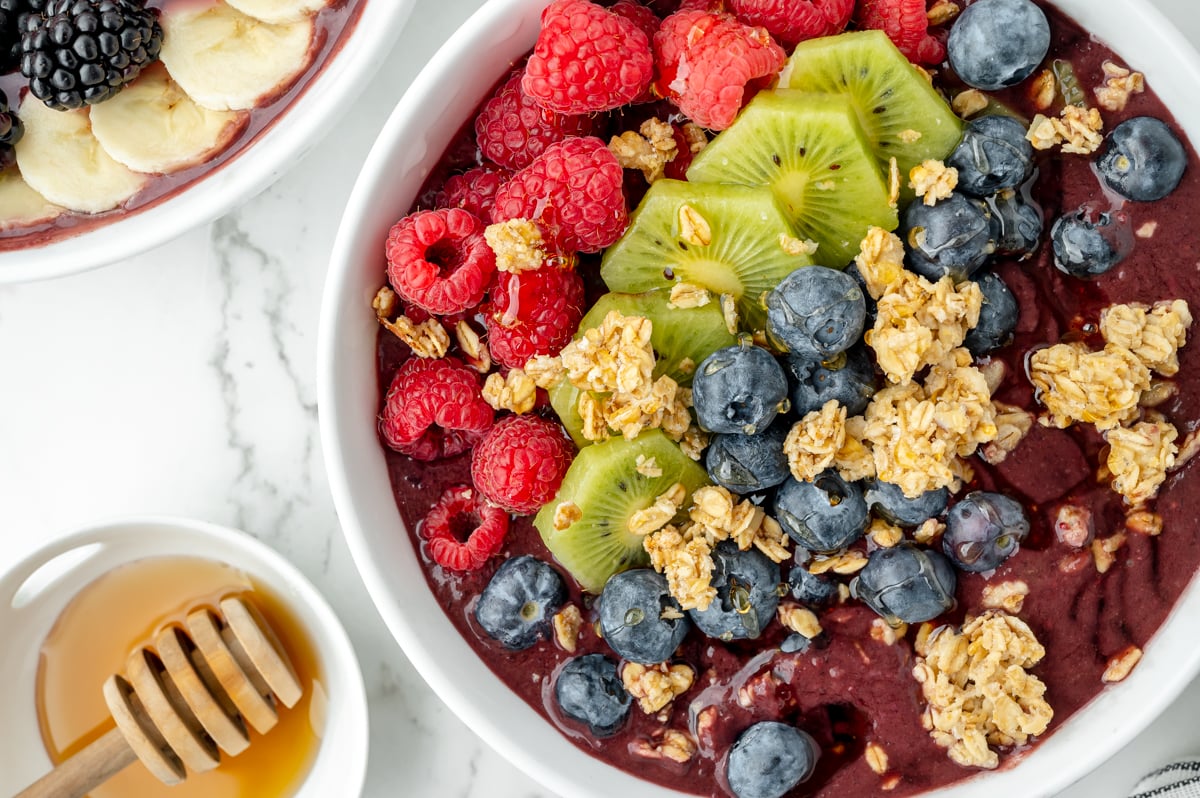 overhead shot of smoothie bowl and bowl of honey