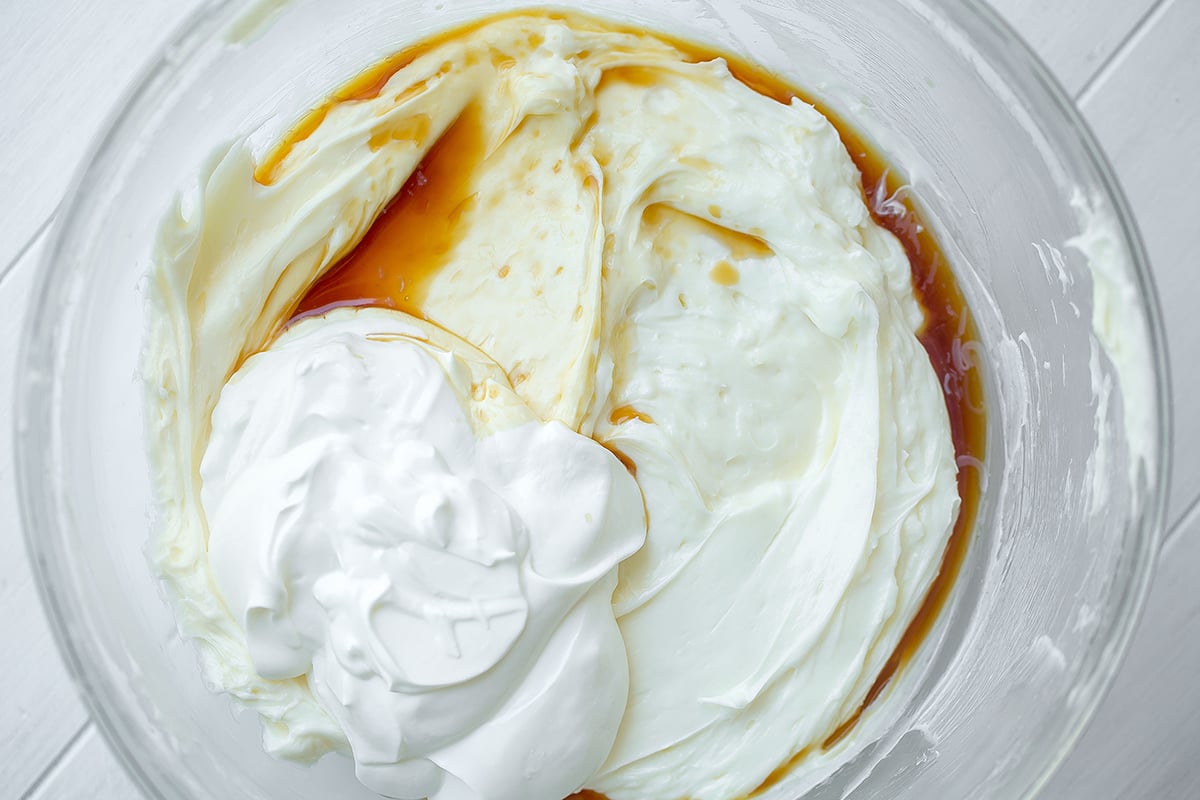 making a cheesecake filling in a glass mixing bowl