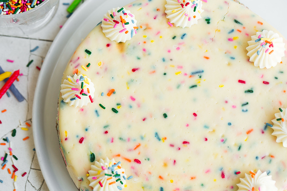 rainbow cheesecake with whipped cream dollops