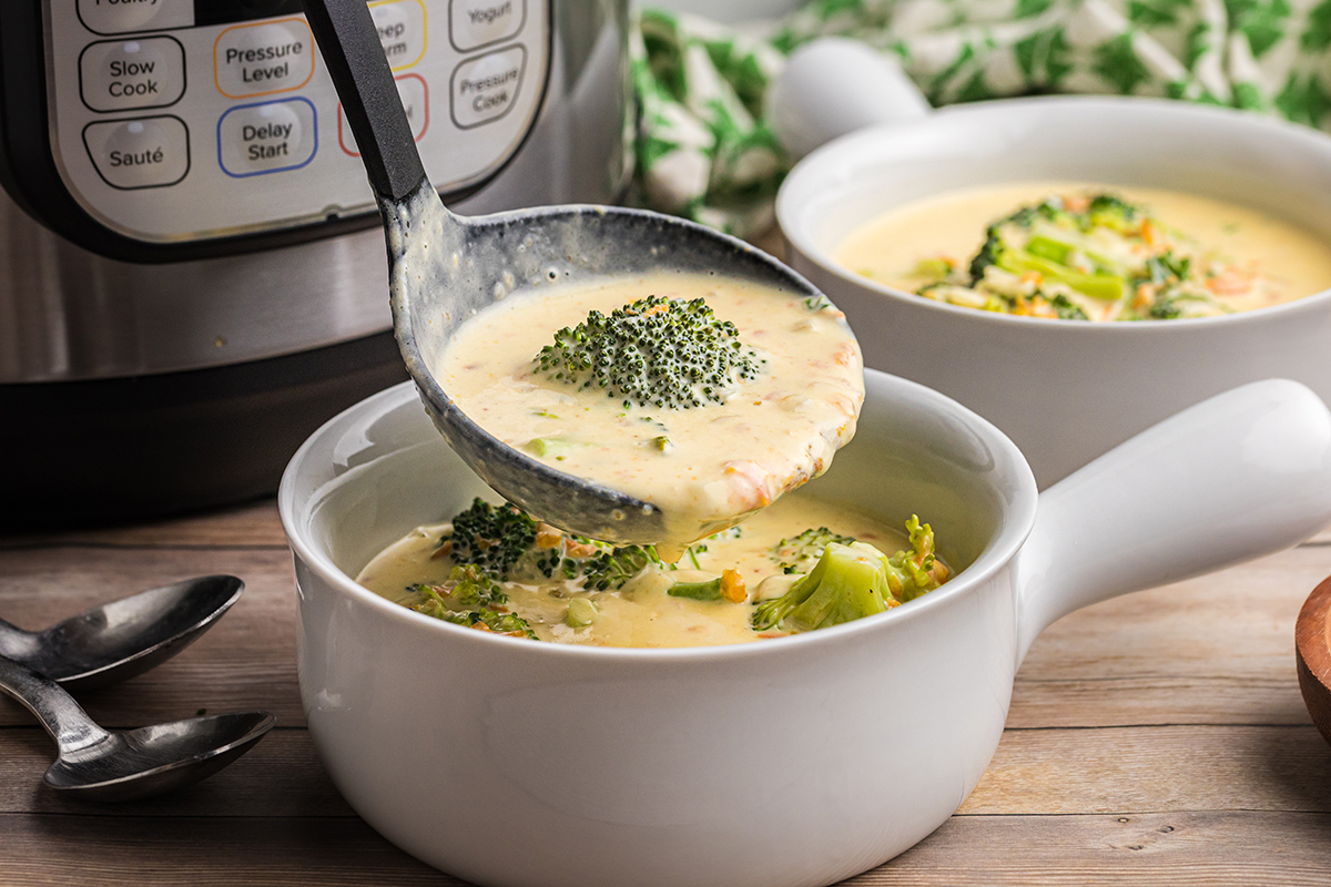 ladling creamy broccoli soup into bowl