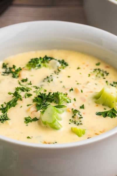 white bowl of creamy cheddar soup with broccoli