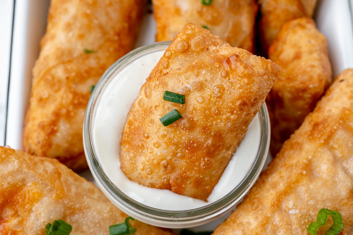 angled shot of egg roll dipped in ranch