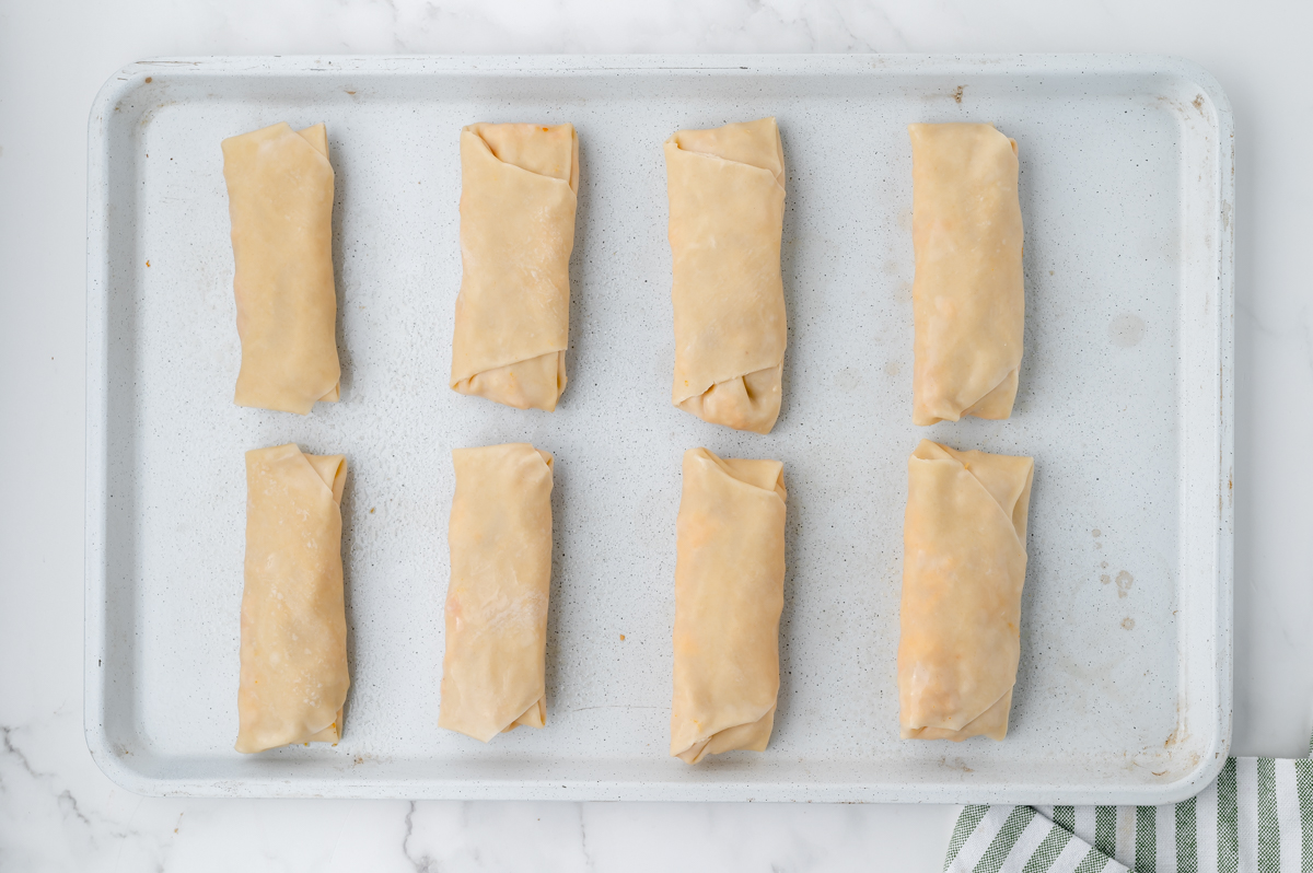 rolled egg rolls on baking sheet