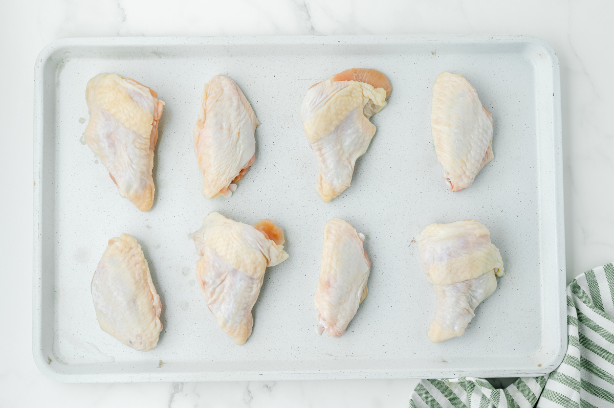 overhead shot of raw wings on baking sheet