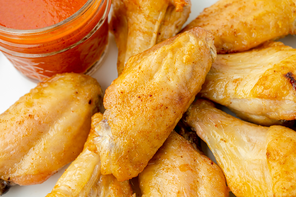 close up angled shot of plate of baked buffalo wings