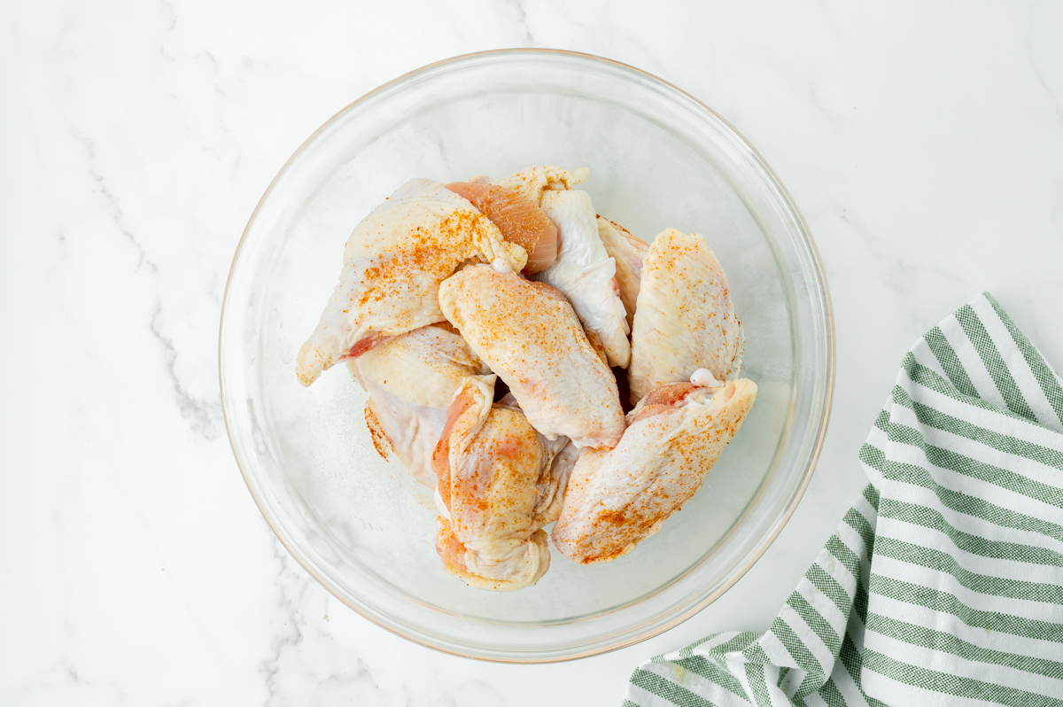 raw chicken wings with seasoning in bowl