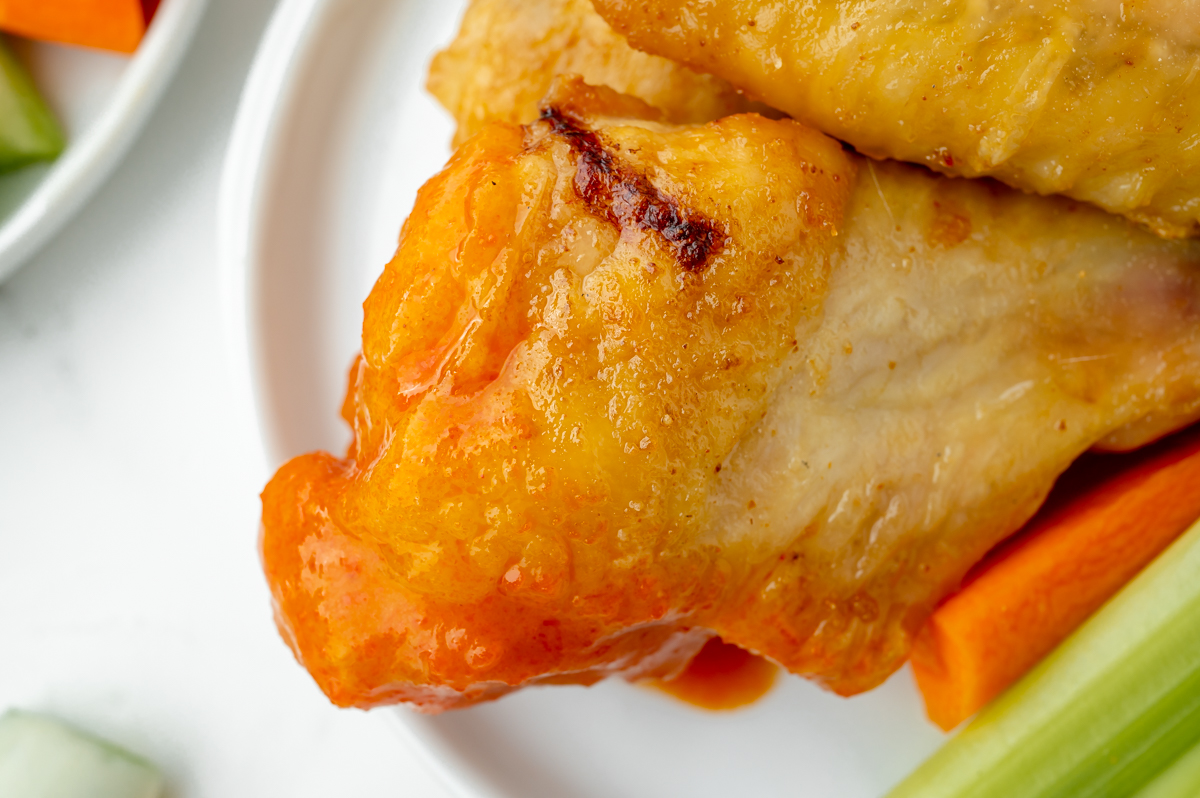 close up overhead shot baked buffalo wing dipped in sauce