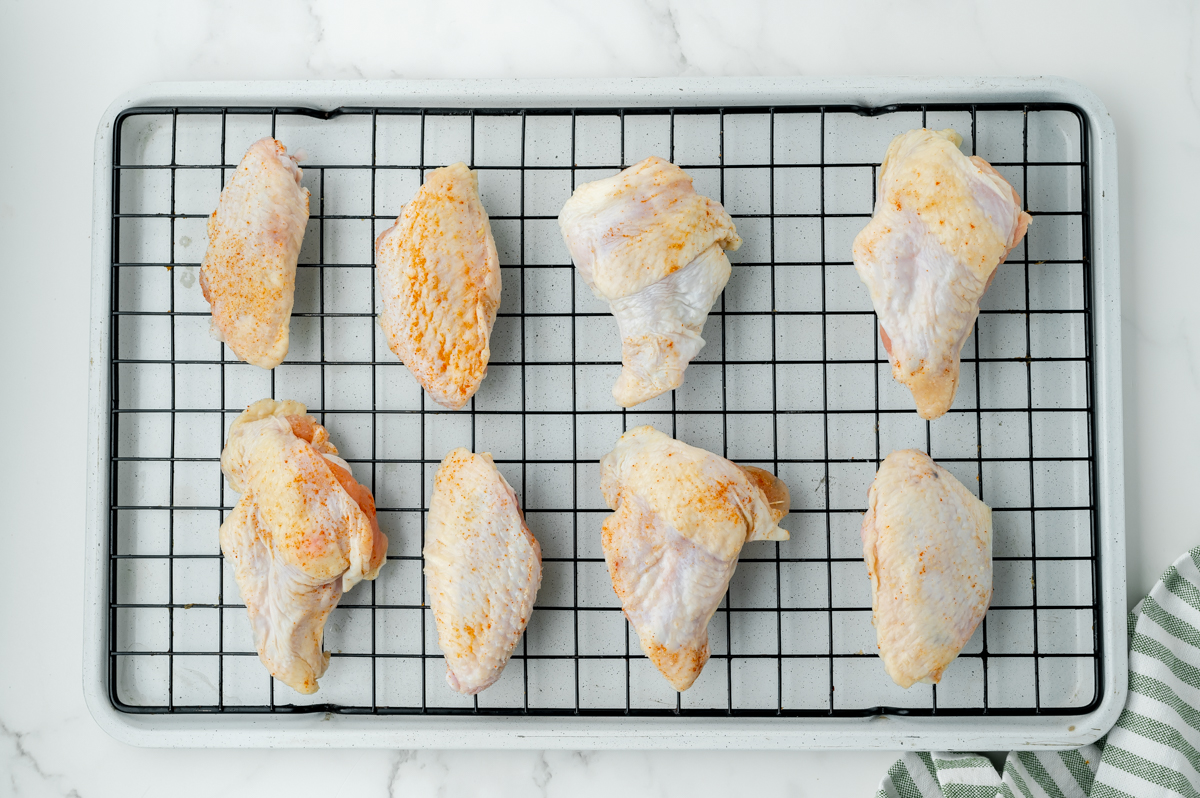 seasoned raw chicken wings on wire rack