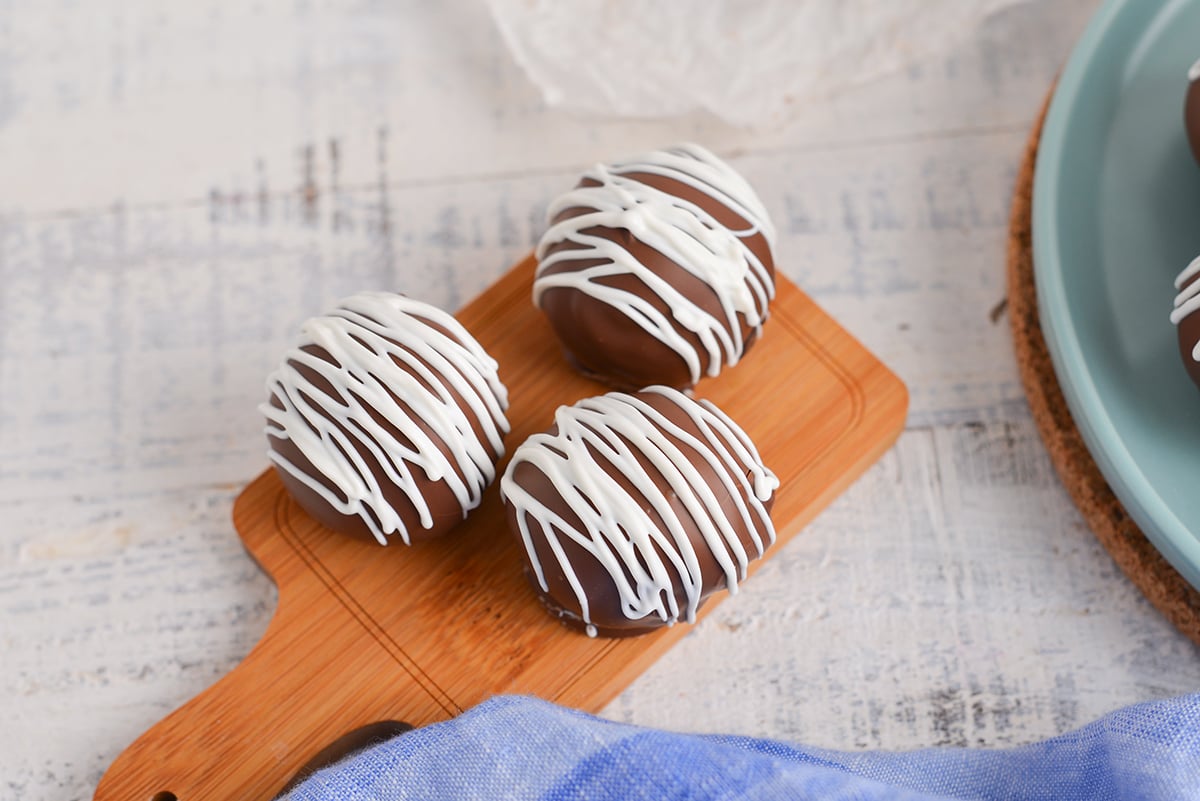 three chocolate cheesecake bites on wooden board