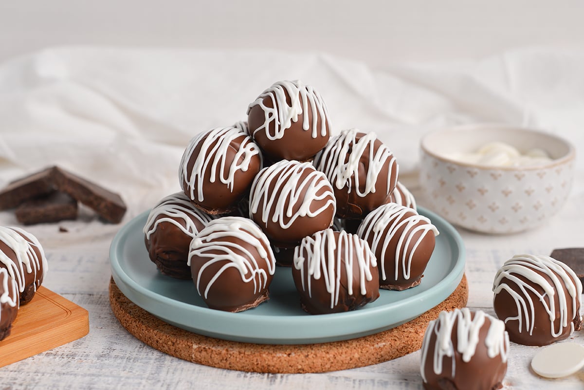 straight on shot of stack of chocolate cheesecake bites on blue plate