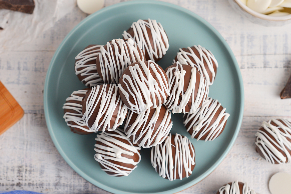 close up overhead shot of stack of chocolate cheesecake bites on blue plate